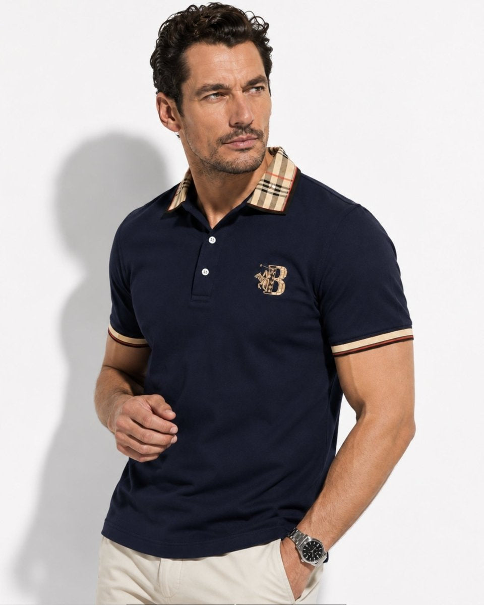 Man wearing a navy polo shirt with a brand logo on a light gray background