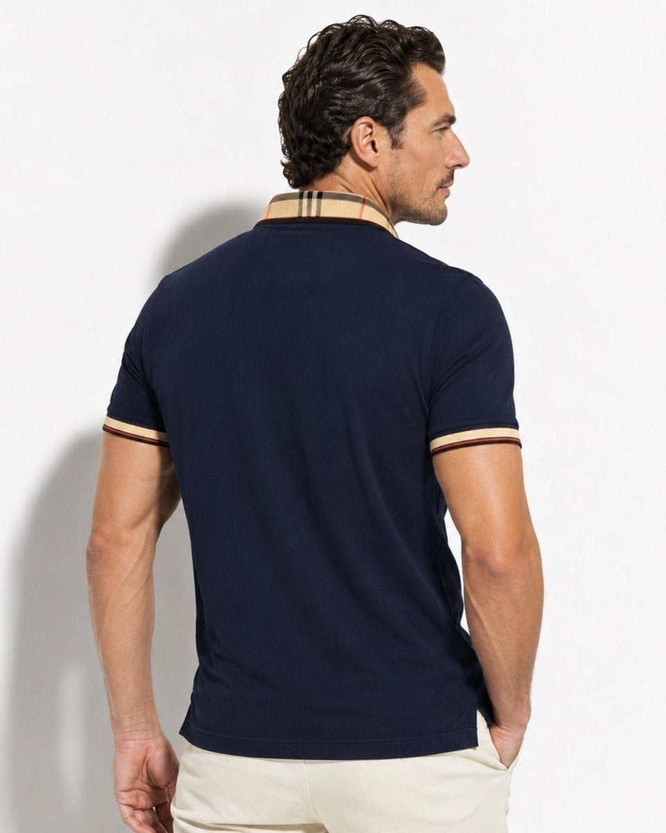 Man wearing a navy polo shirt with beige accents on a light gray background