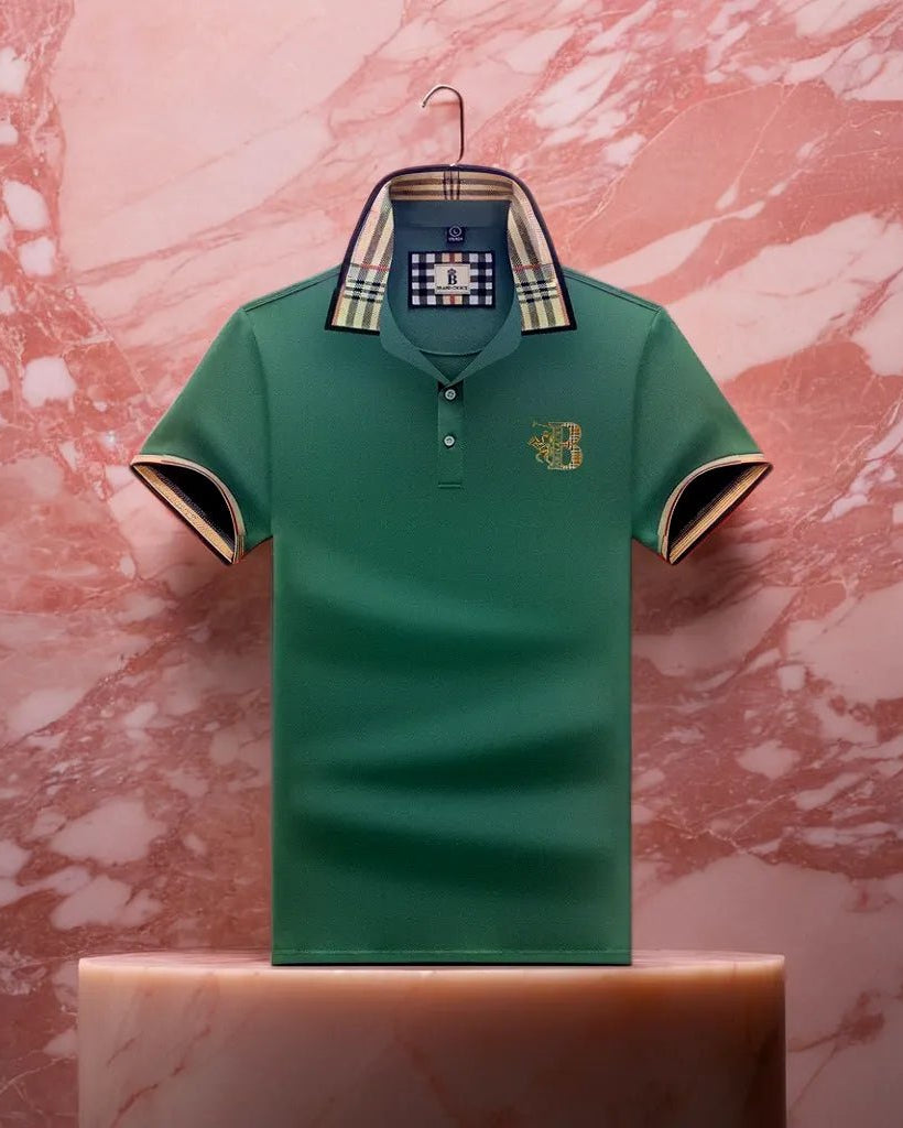 Green polo shirt with plaid collar on a hanger against a pink marble background
