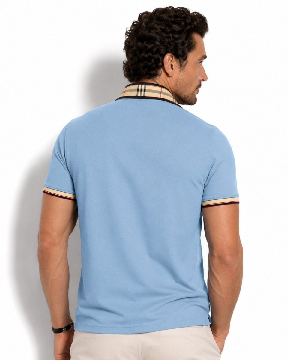 Man wearing a light blue polo shirt with a patterned collar against a white background