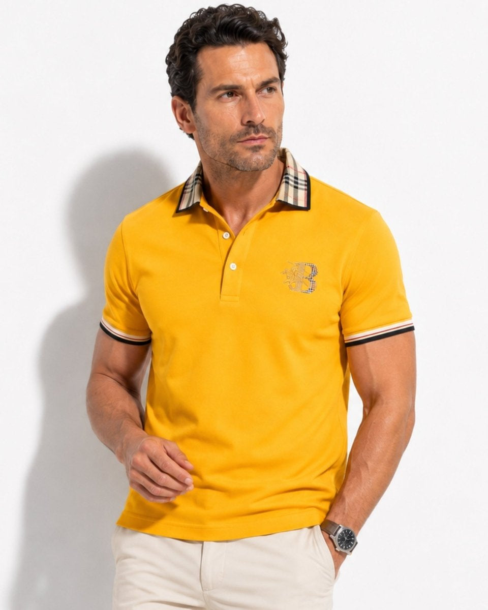 Man wearing a yellow polo shirt with a brand logo on a white background