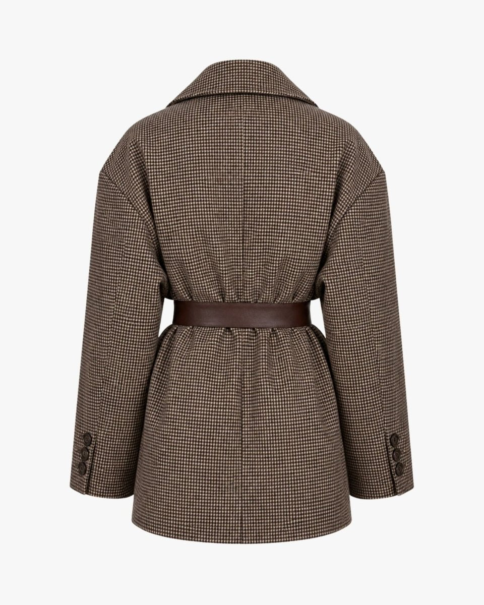 A brown and beige houndstooth belted coat shown from the back, featuring a structured collar, long sleeves with button cuffs, and a matching brown belt at the waist, set against a plain light gray background.