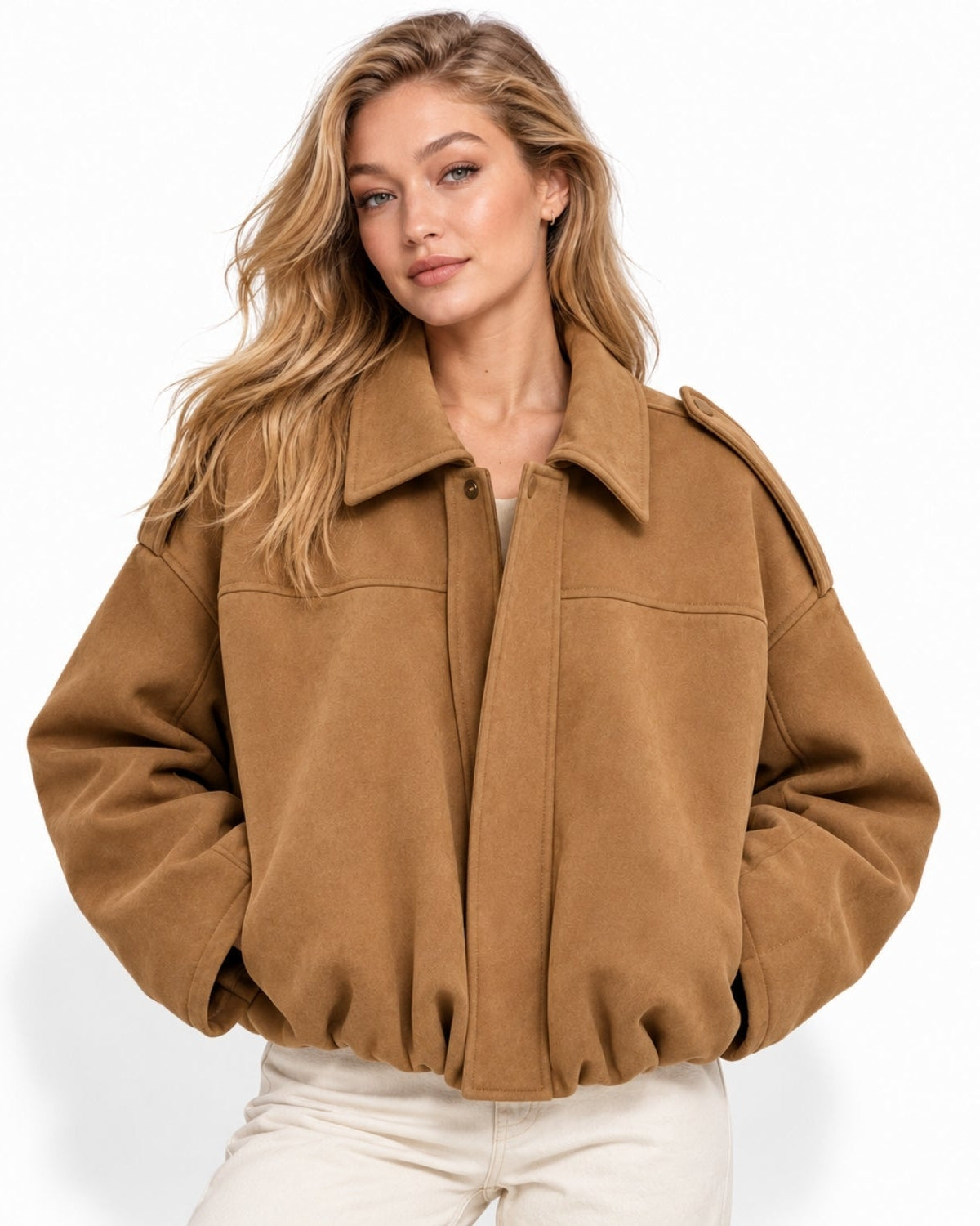 A woman wearing a cropped camel brown suede jacket with a wide collar and front button closure, paired with off-white pants, against a clean white background.