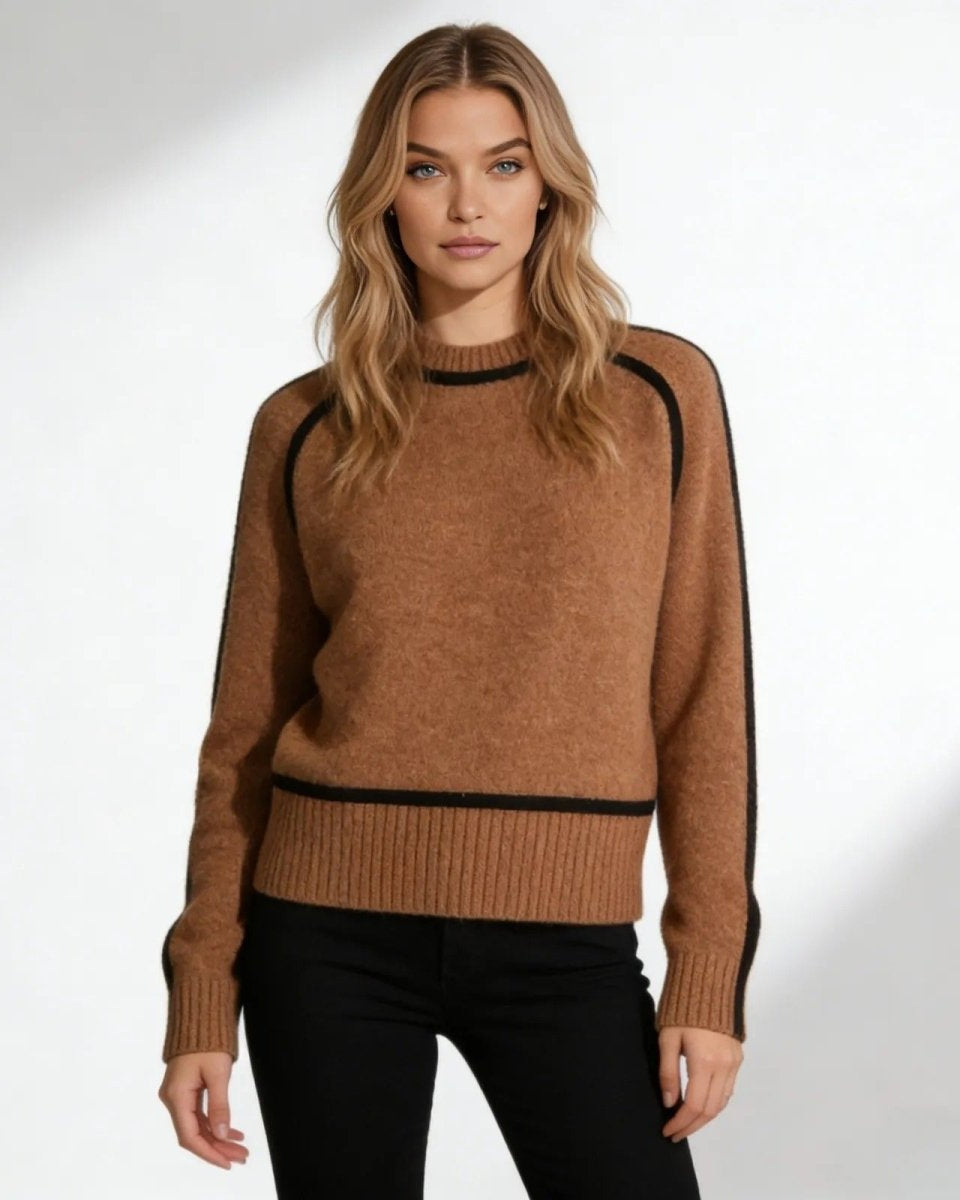 Model wearing the brown wool turtleneck sweater with black piping detail, paired with black pants.