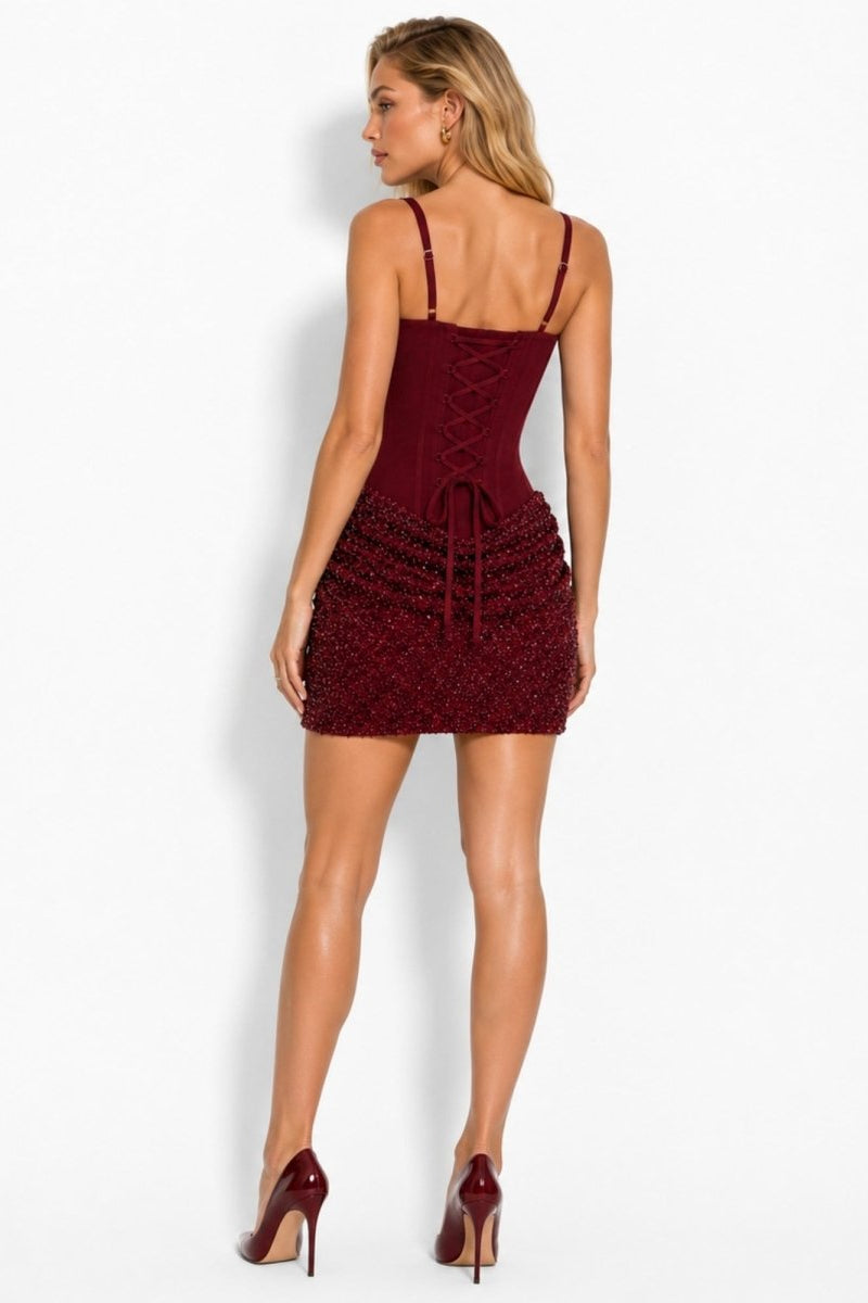 Back view of the burgundy red cocktail dress featuring a structured lace-up corset back.