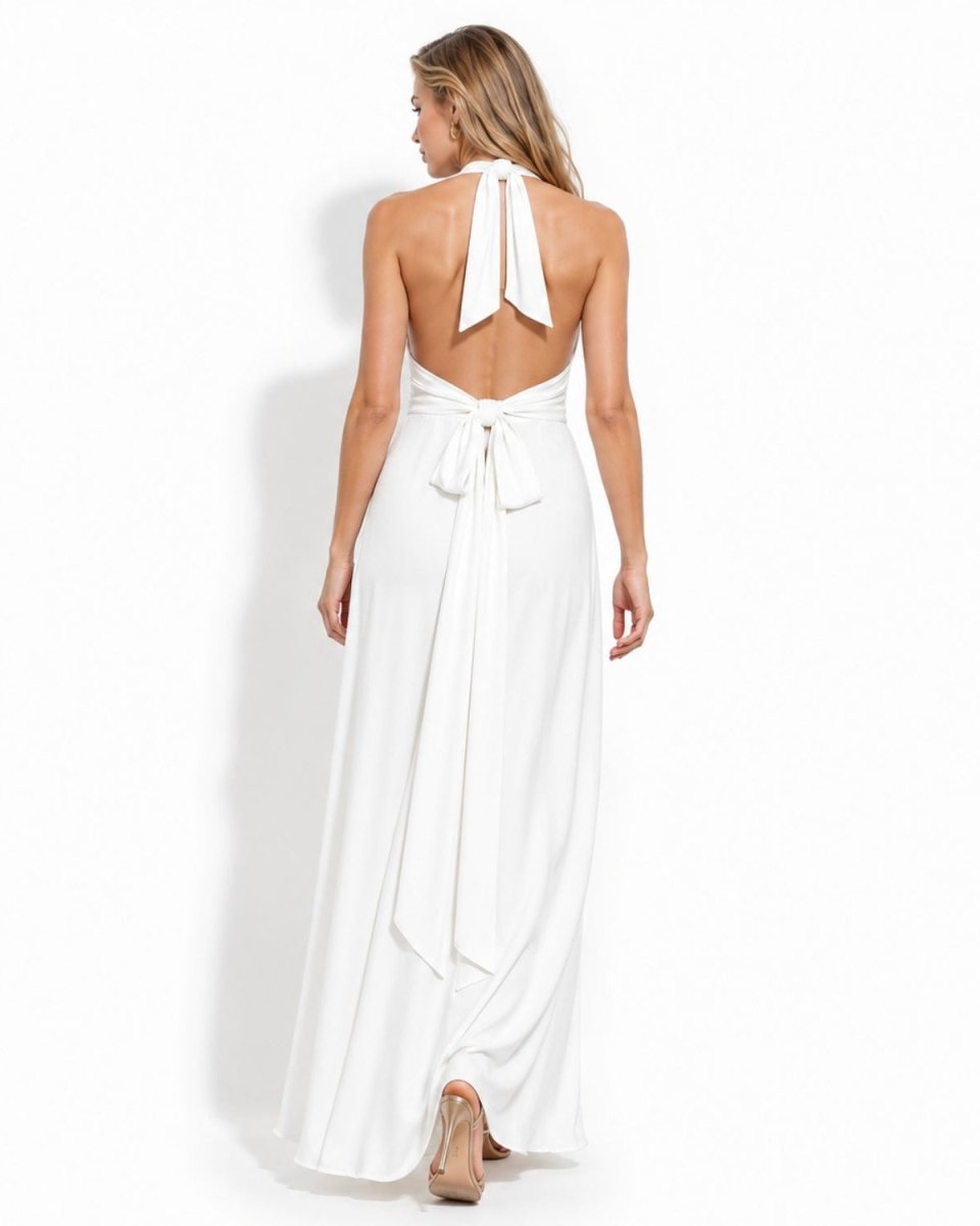 A woman modeling a white halter-neck maxi dress from the back, featuring a tie-back design and open back, set against a plain white studio background.