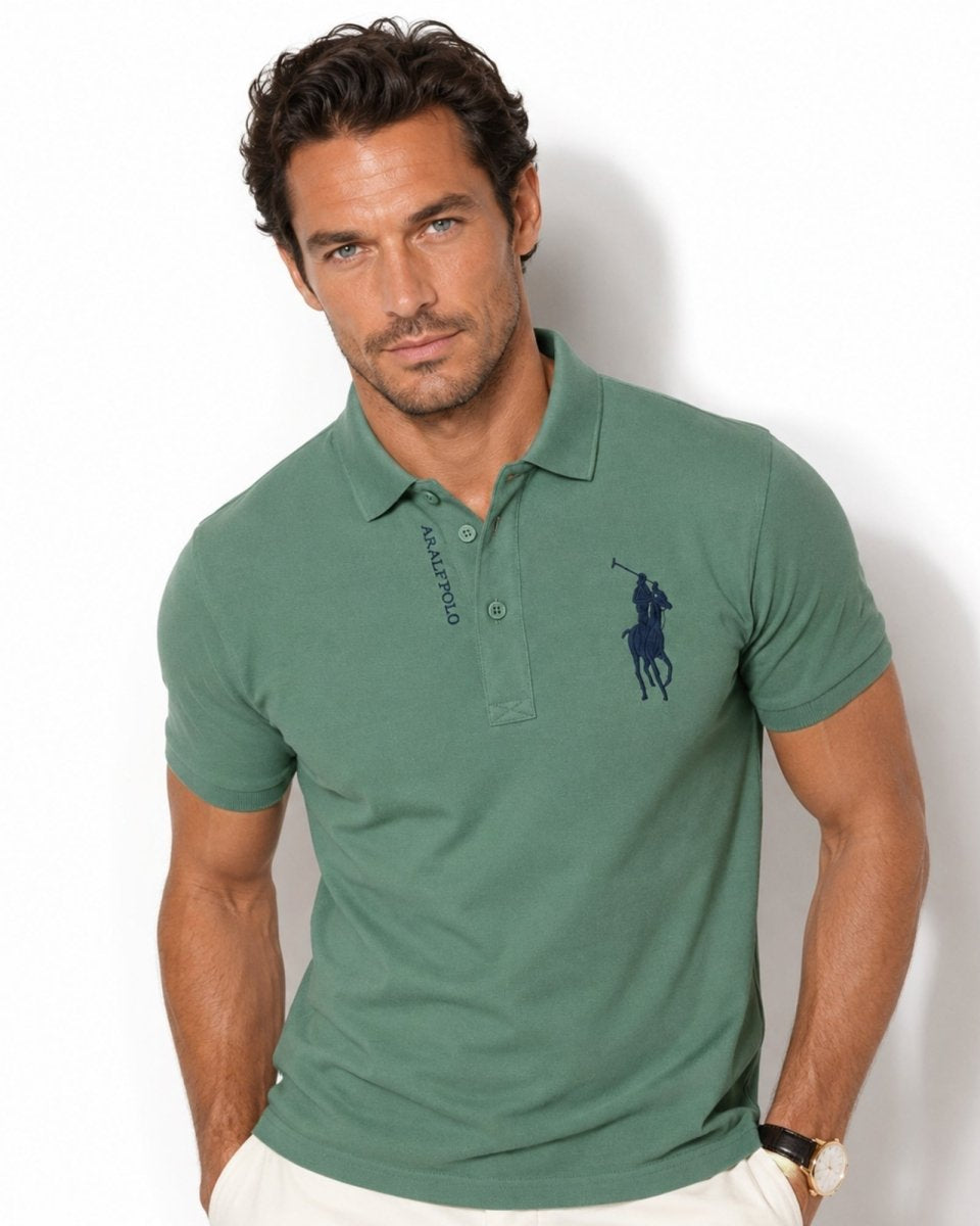 Man wearing a green polo shirt with a logo on a white background
