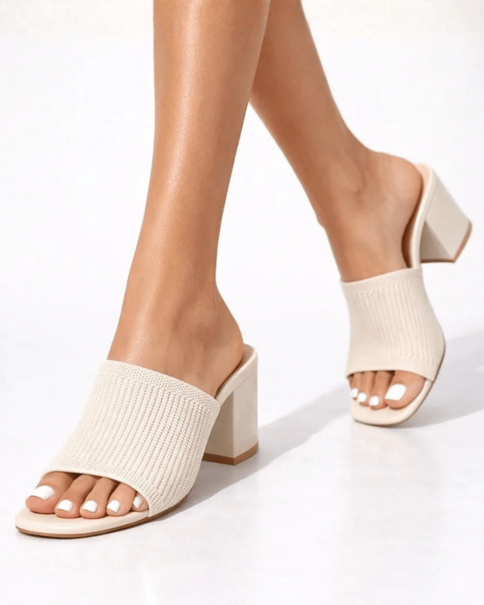 Woman walking in cream ribbed knit square toe block heel slip-on mules