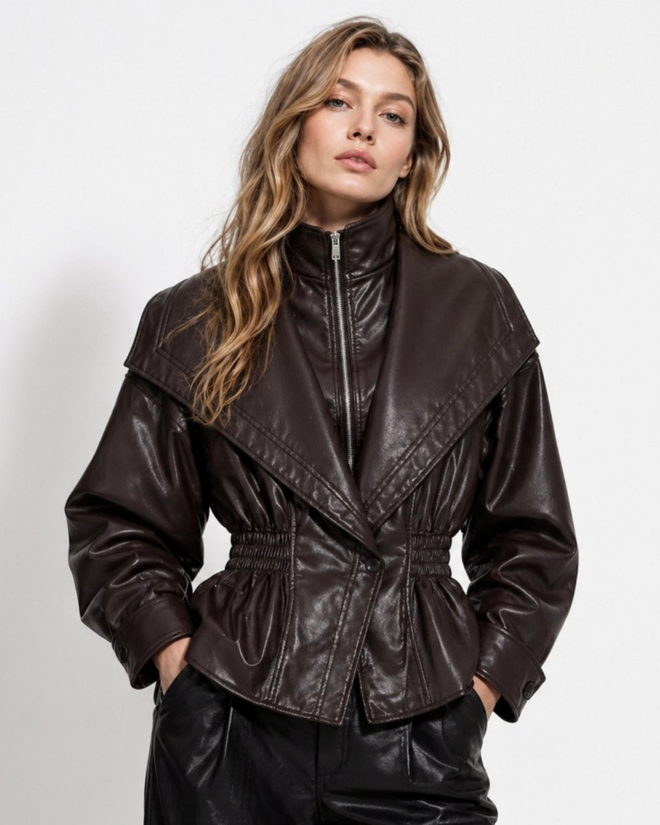 Woman wearing a dark brown faux leather peplum jacket with oversized collar and smocked waist, front view.