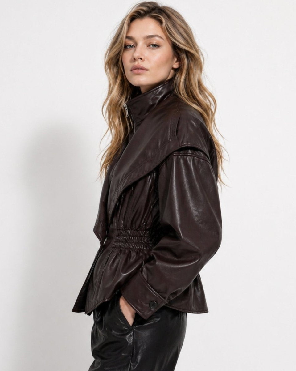 Side profile of woman wearing dark brown faux leather jacket with balloon sleeves and peplum hem.