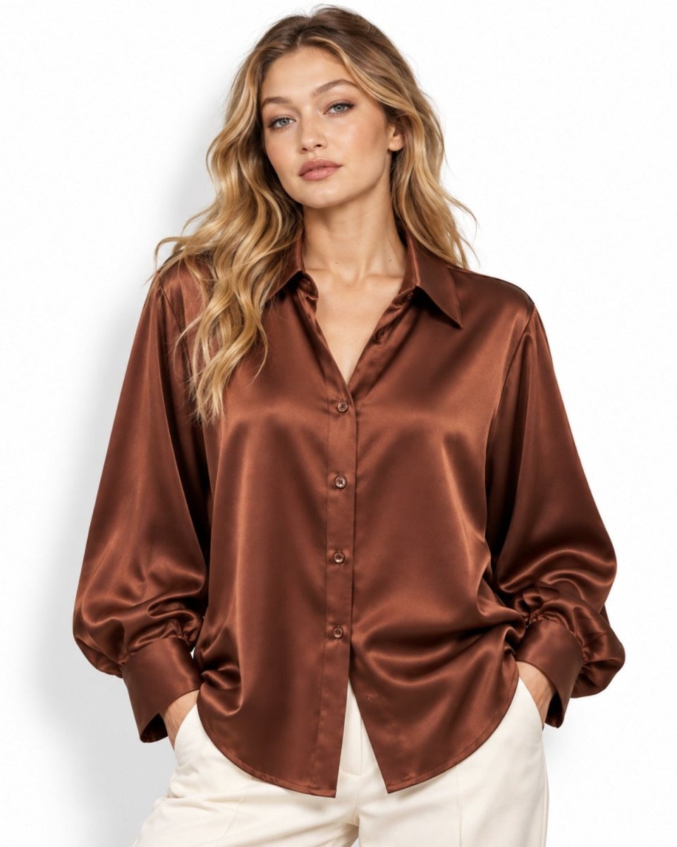 Woman wearing luxurious dark brown silk button down blouse with balloon sleeves tucked into trousers