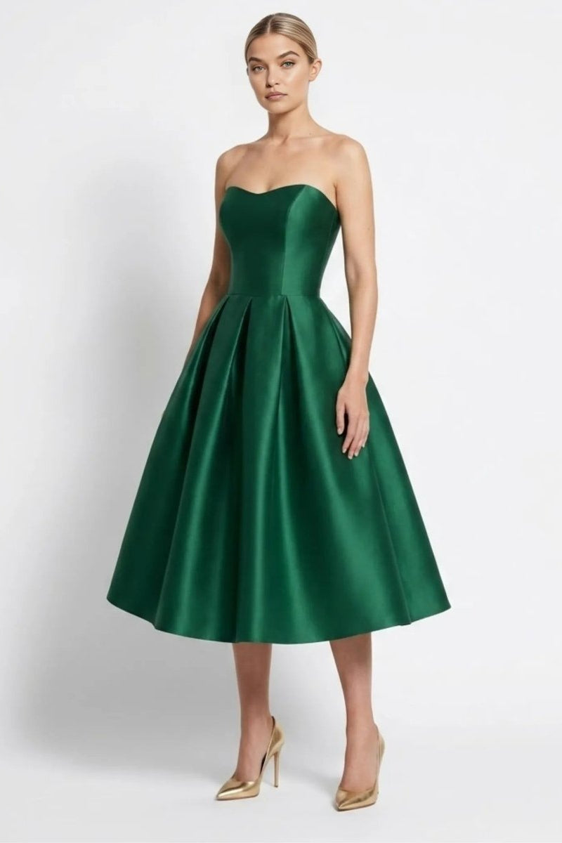 Front view of a woman wearing an elegant dark green strapless satin midi dress with a sweetheart neckline and A-line pleated skirt.