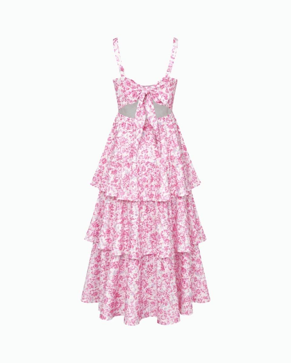 A pink and white floral print tiered maxi dress with spaghetti straps, a sweetheart neckline, and a bow detail at the center bust, shown against a plain white background.