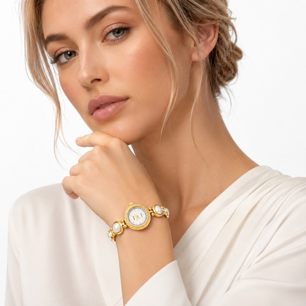 Fashion model wearing the Kouvr vintage gold pearl bracelet watch styled with an elegant white silk halter dress.