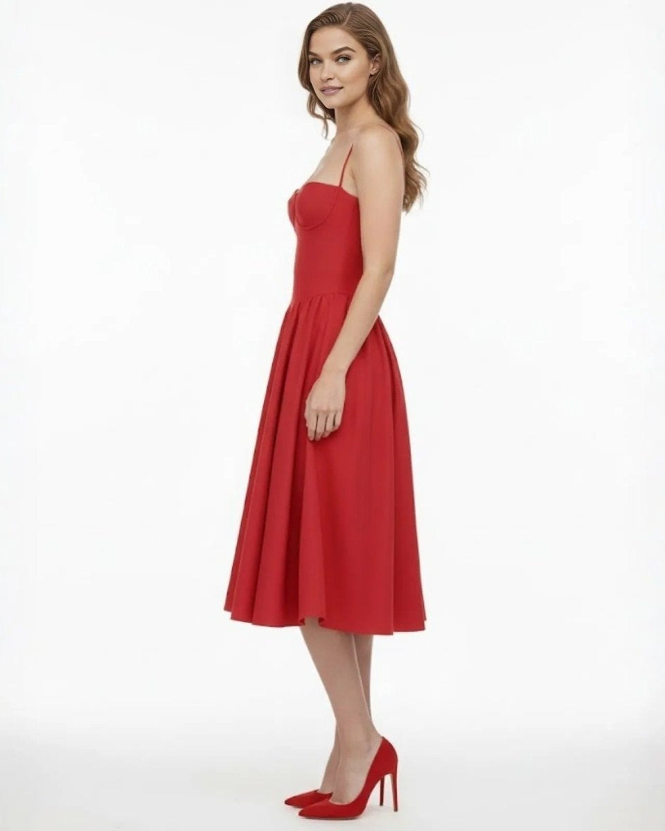 Side profile of a model in the Evdokia red A-line midi dress showcasing the fitted corset bodice and flow of the full skirt.