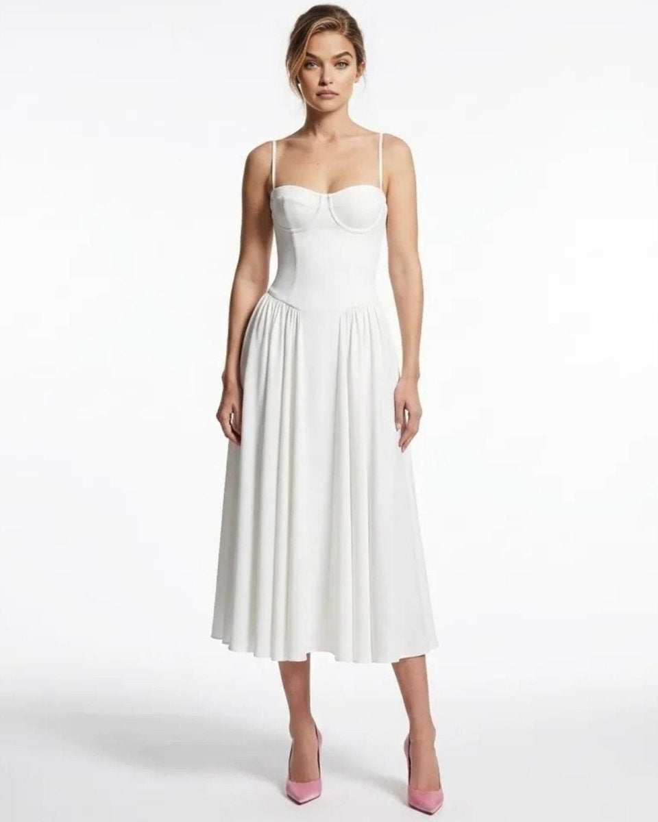 Model wearing the Evdokia white corset bustier midi dress, front view, styled with pink heels. 