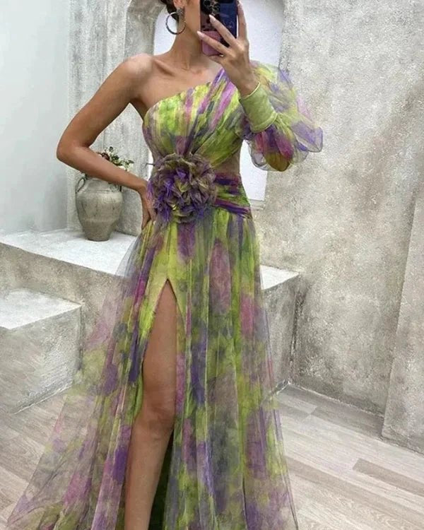 Woman wearing a green and purple floral dress with a high slit, standing in a bathroom.