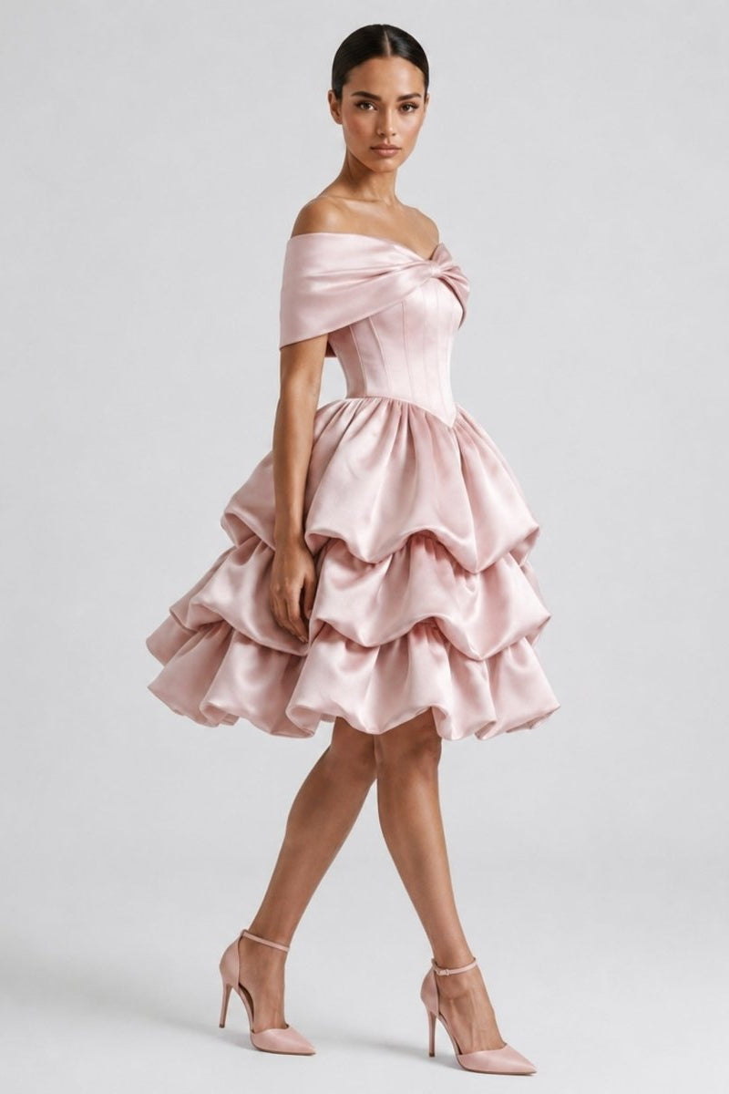 Side profile of woman in Fenlo Form pink satin off the shoulder party dress showing voluminous tiered skirt and bow detail.