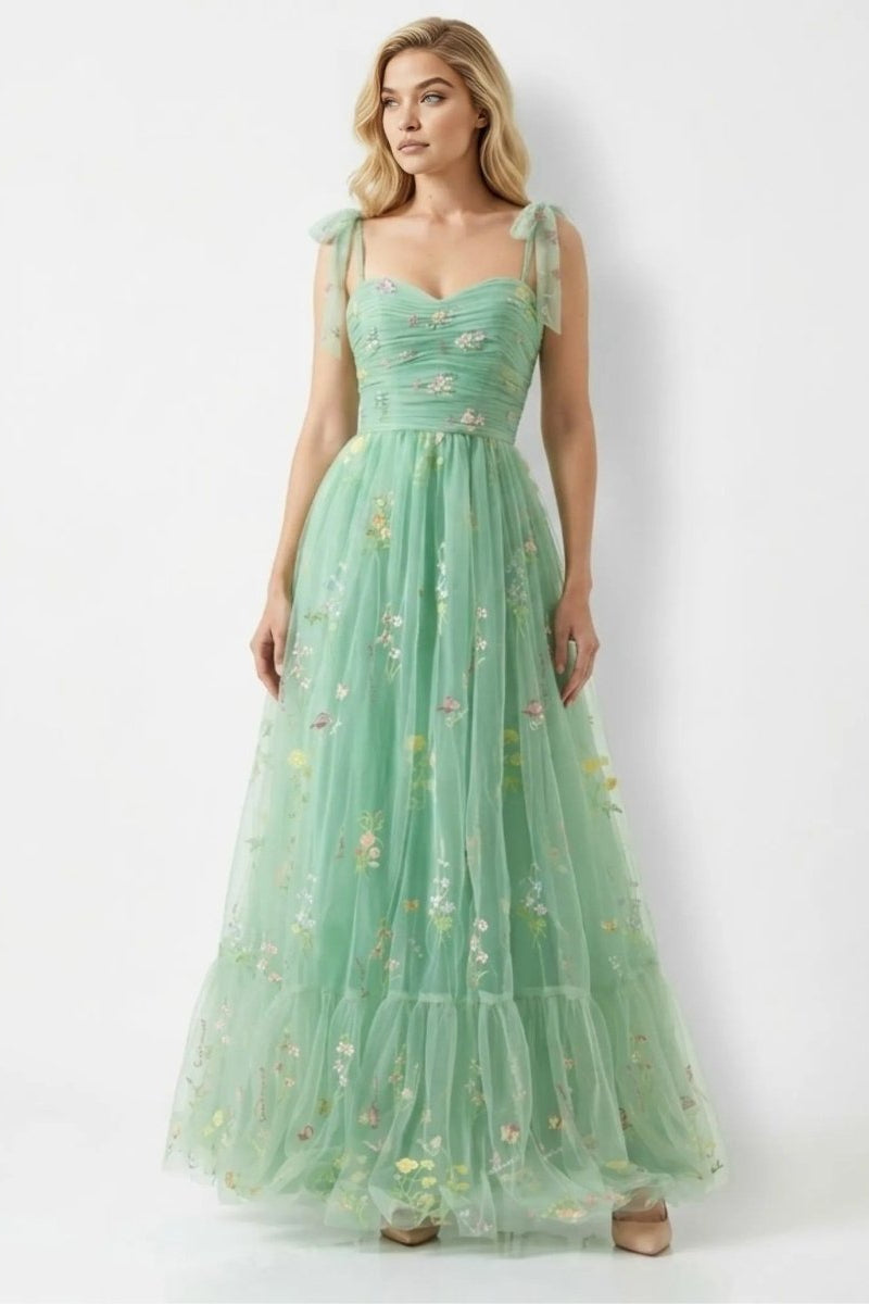 Woman wearing a mint green floral dress on a white background