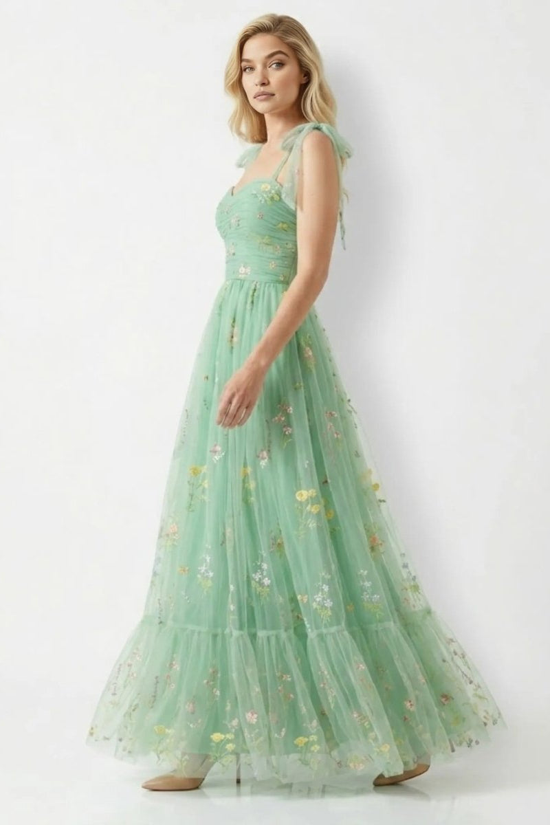 Woman wearing a green floral dress on a white background
