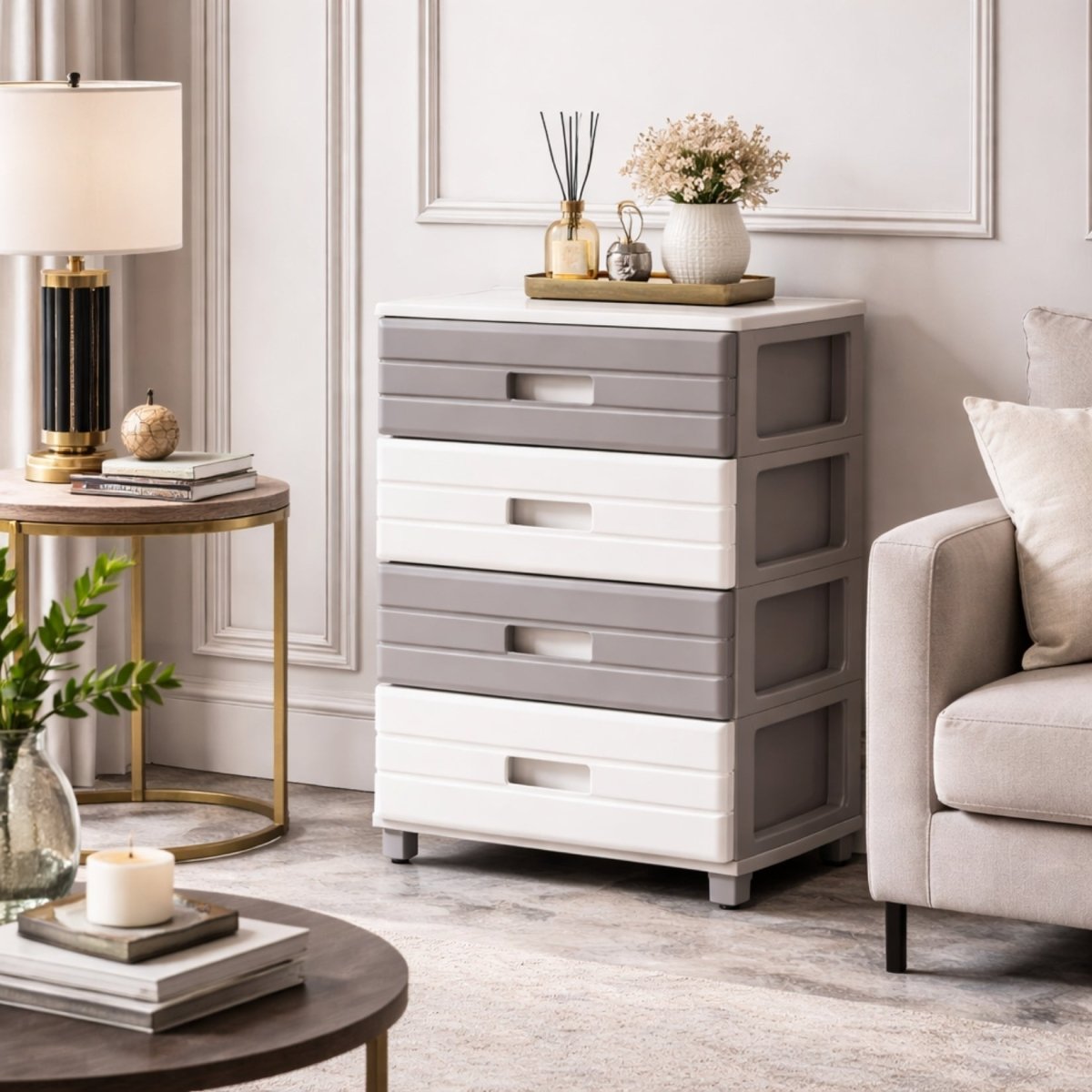 Four-tier grey and white freestanding drawer unit placed elegantly next to a beige armchair in a bright living space.