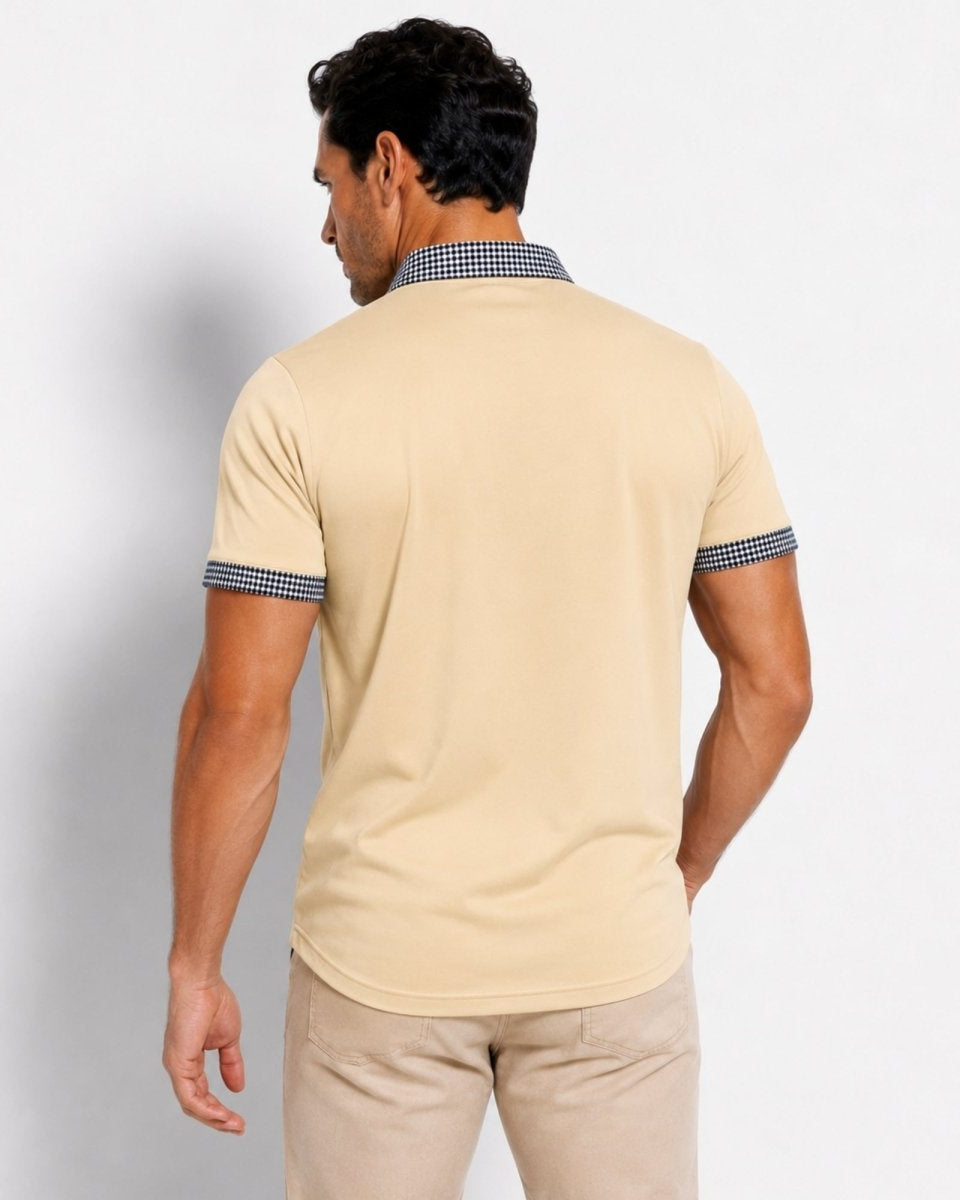 Man wearing a beige polo shirt with checkered collar and sleeves on a plain background