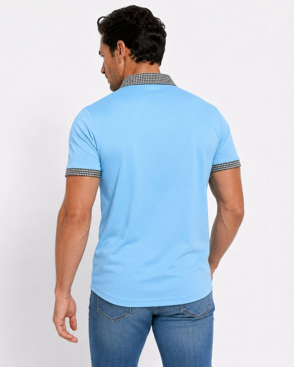 Man wearing a light blue polo shirt with dark jeans on a white background