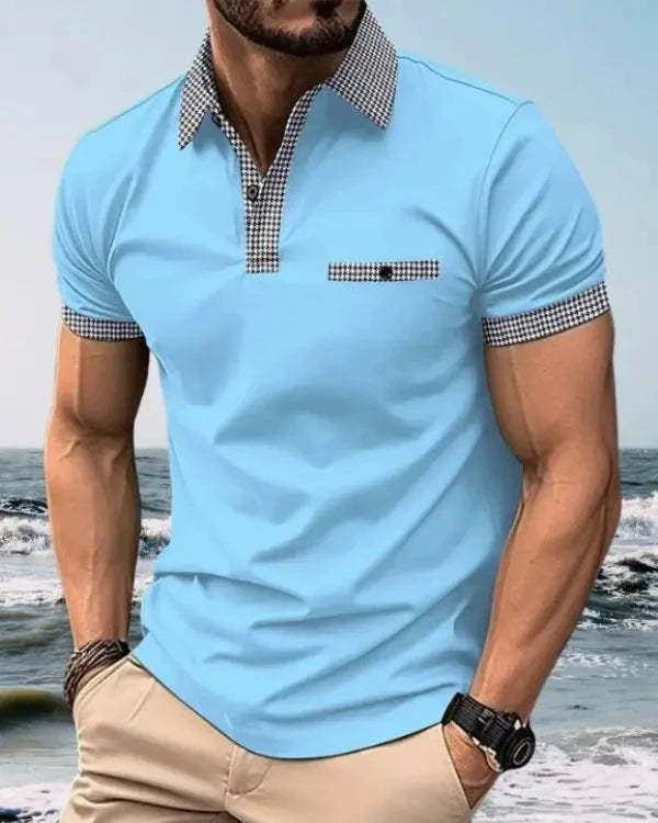 Man wearing a light blue polo shirt with checkered collar and cuffs on a beach.
