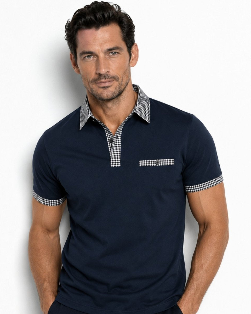 Man wearing a navy blue polo shirt with checkered details on a white background