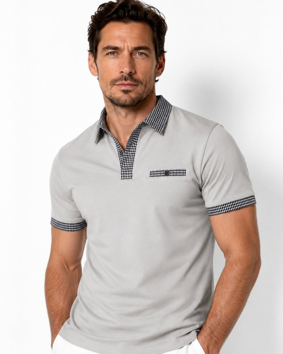 Man wearing a gray polo shirt with checkered collar and cuffs on a white background