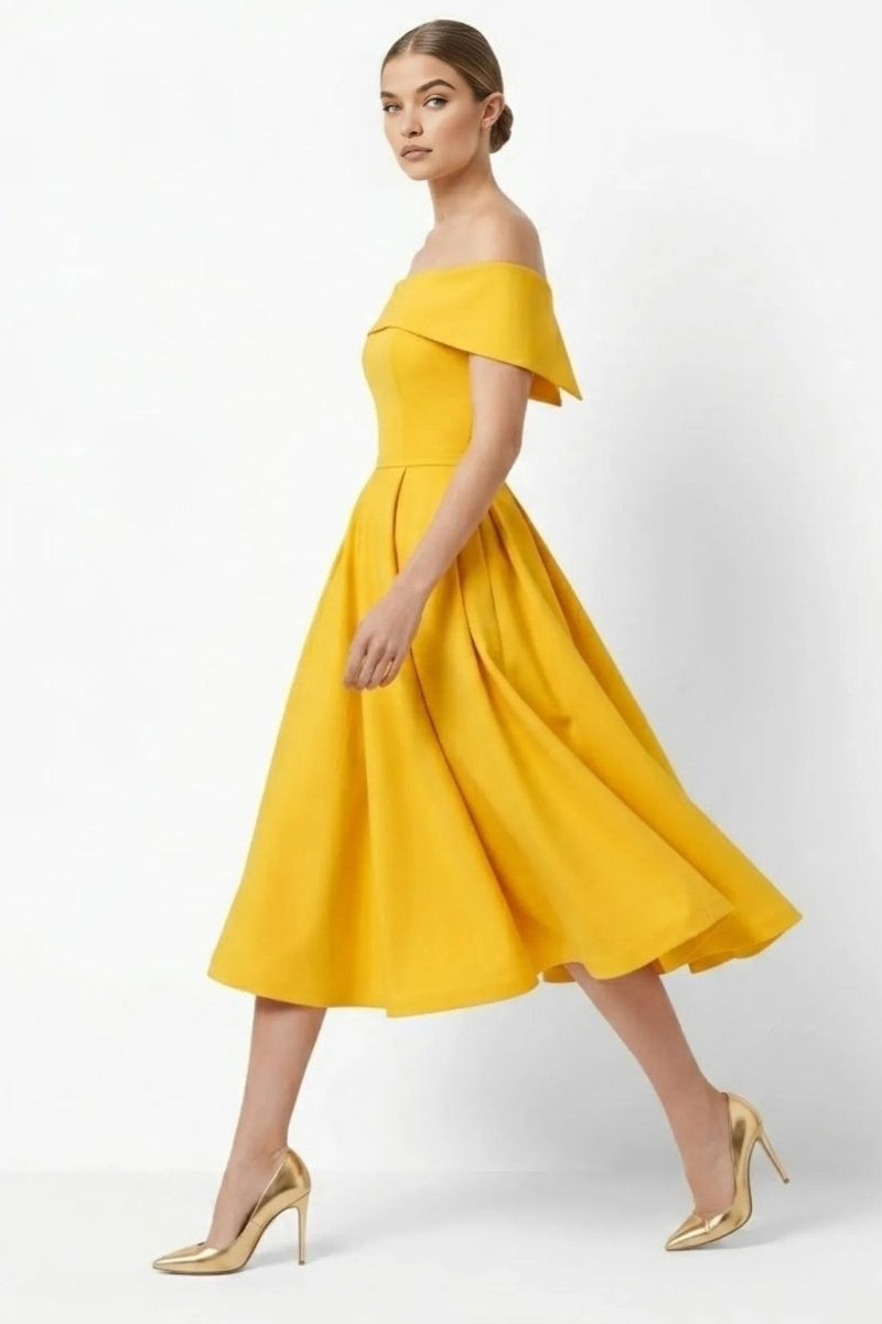 Side profile of woman walking in flowing gold fit and flare cocktail dress with metallic heels