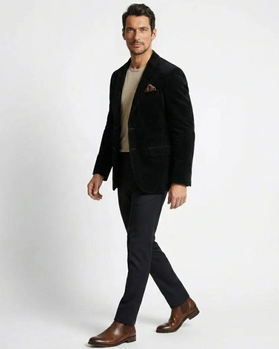 Side profile of a man walking in a black Italian corduroy sport coat, showing the jacket's drape and fit.