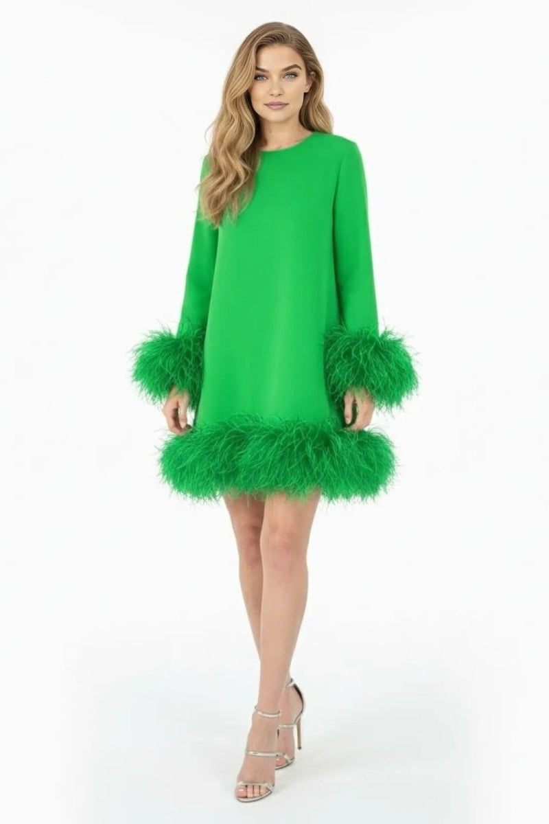 Model wearing Kouvr's green long sleeve mini dress with genuine ostrich feather trim on the cuffs and hem, shown from the front against a white background.