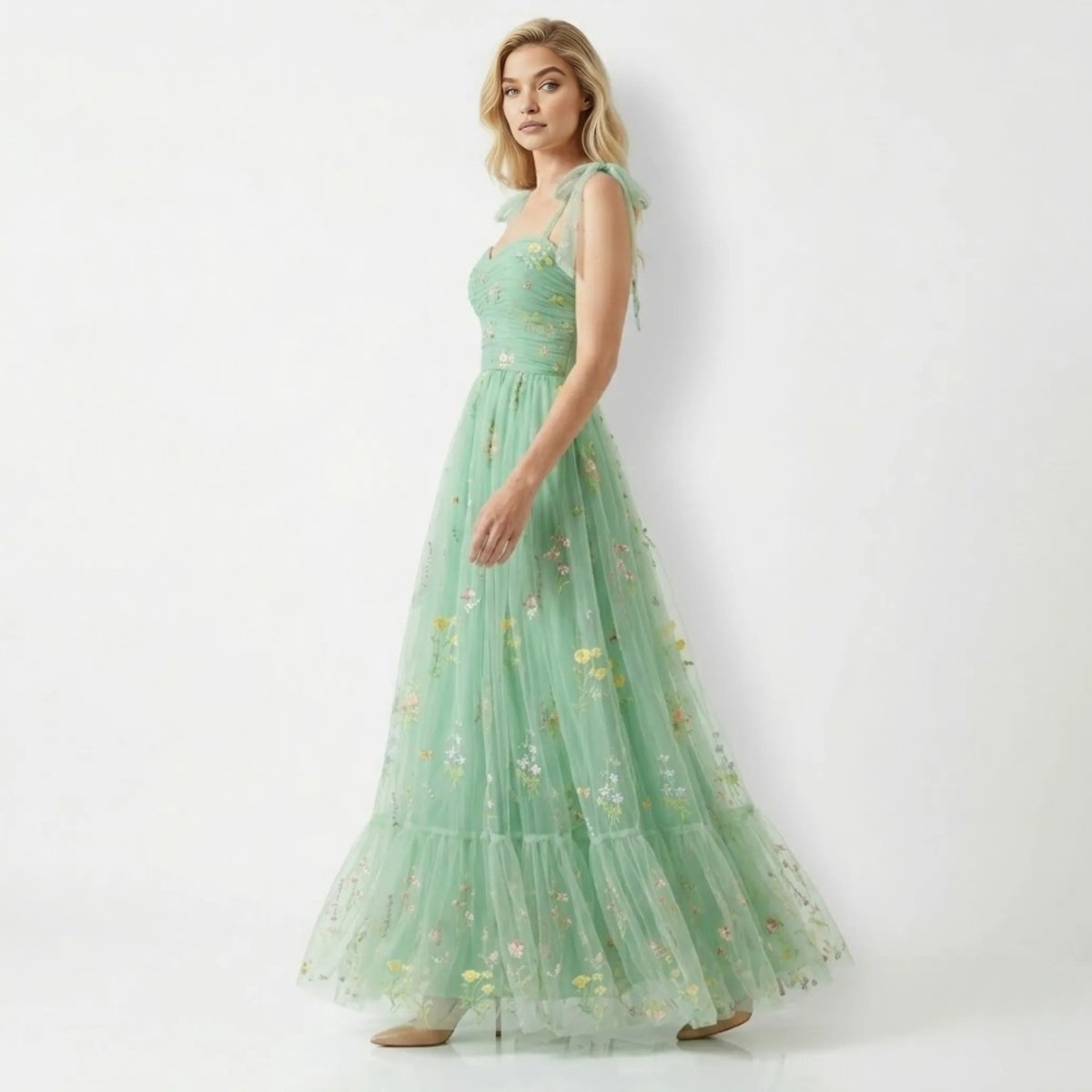 Side angle view of Kouvr romantic green tulle sweetheart gown showcasing flowing tiered skirt