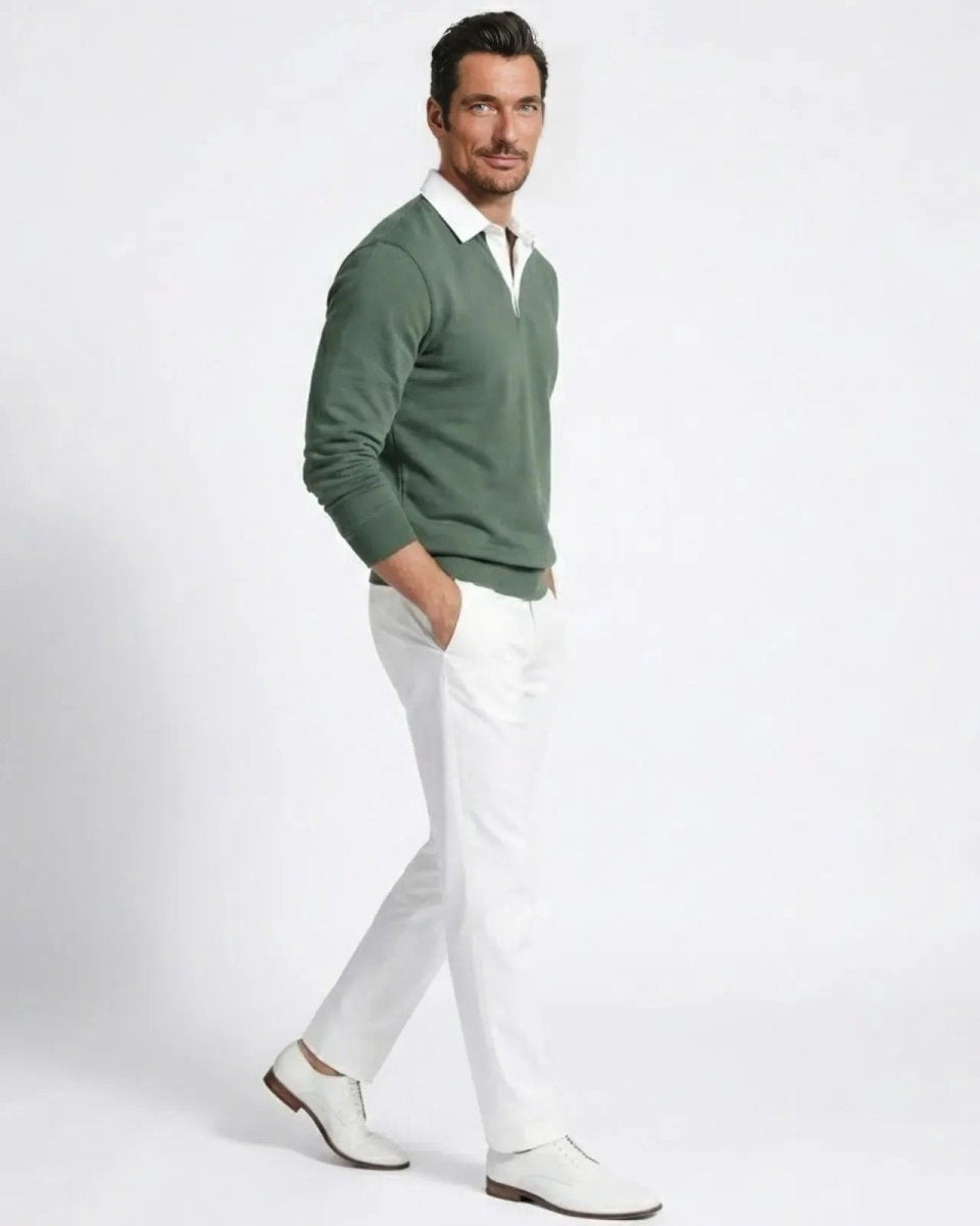 Side profile of a man walking in the  green long-sleeve knit polo, showcasing its tailored fit.
