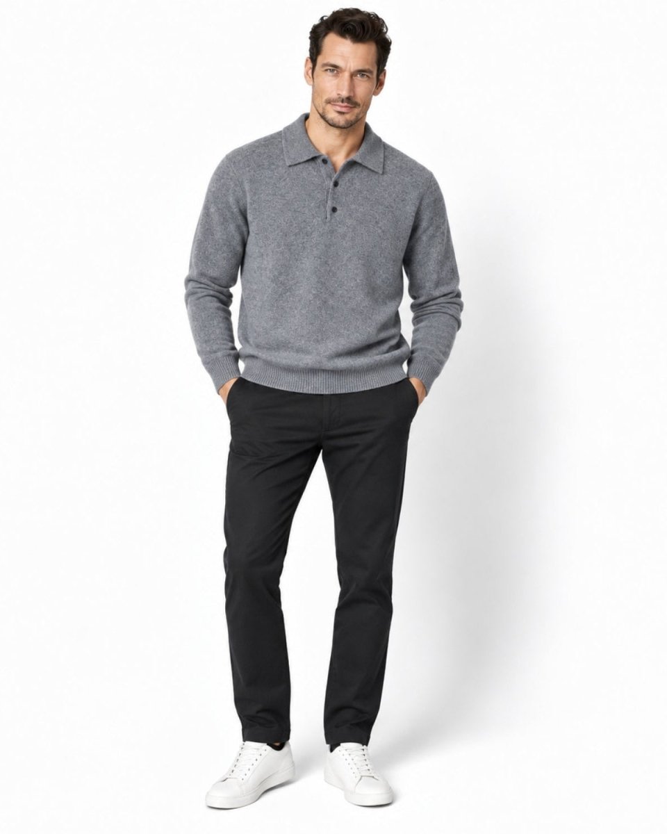A man modeling a gray long-sleeve polo knit sweater, paired with black trousers and white sneakers, standing against a clean white studio background.