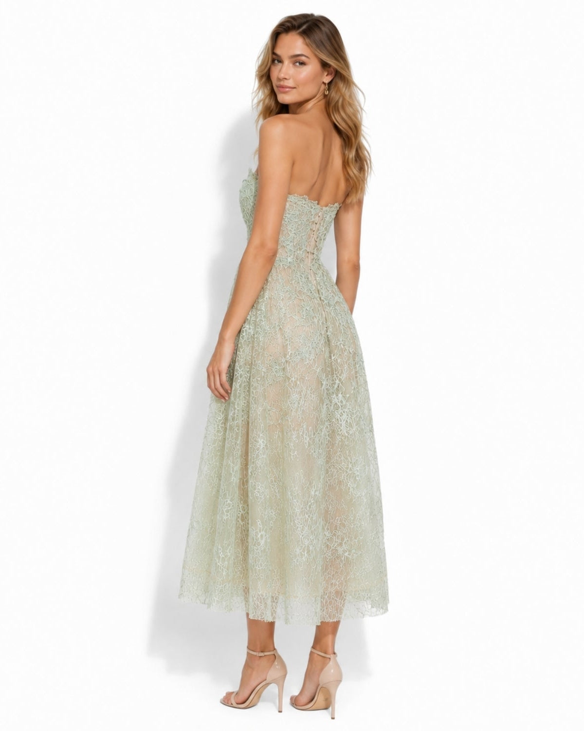 A woman modeling a strapless lace midi dress with a fitted bodice and flowing skirt, shown from the back against a clean white studio background.