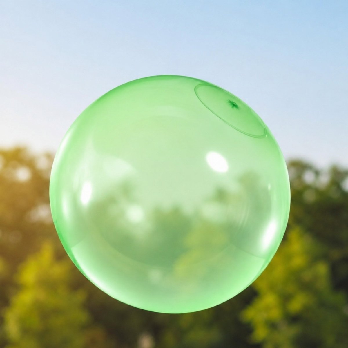 Green giant inflatable jelly ball floating outdoors; a durable and stretchable toy for children.