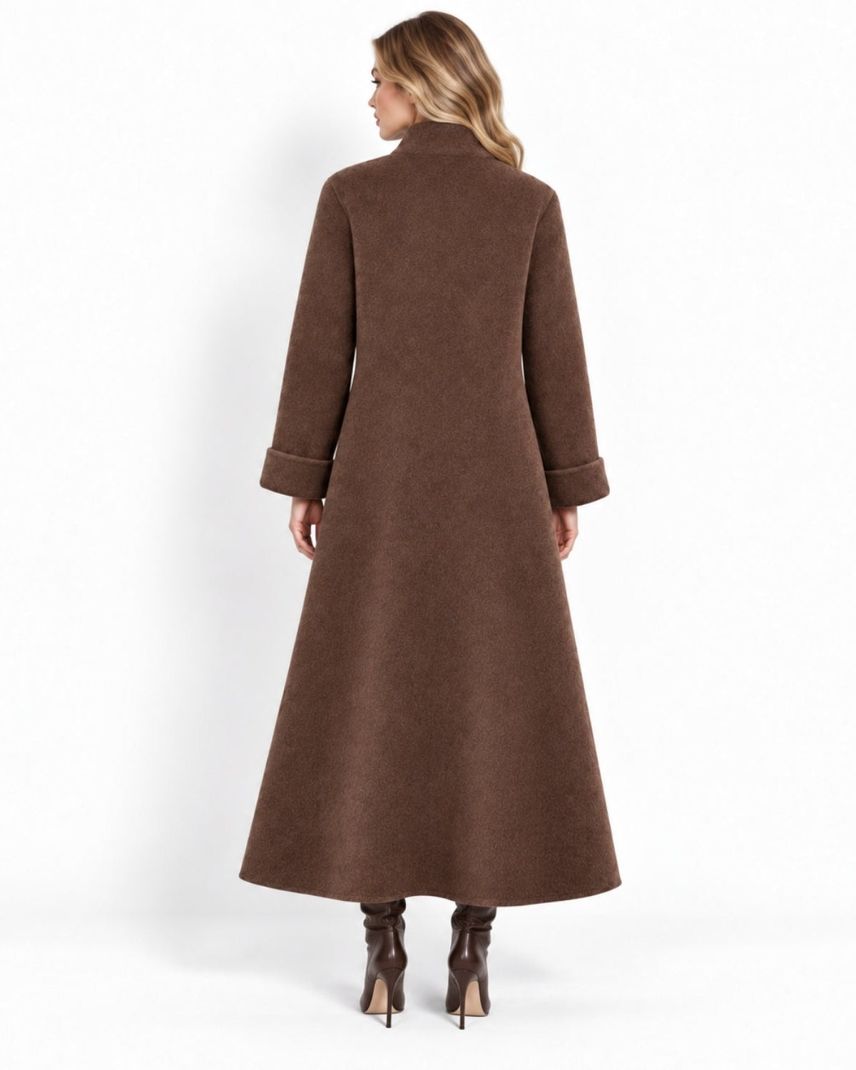 A woman shown from the back wearing a long wool-blend coat with cuffed sleeves and dark brown heeled ankle boots, photographed against a clean white studio background.