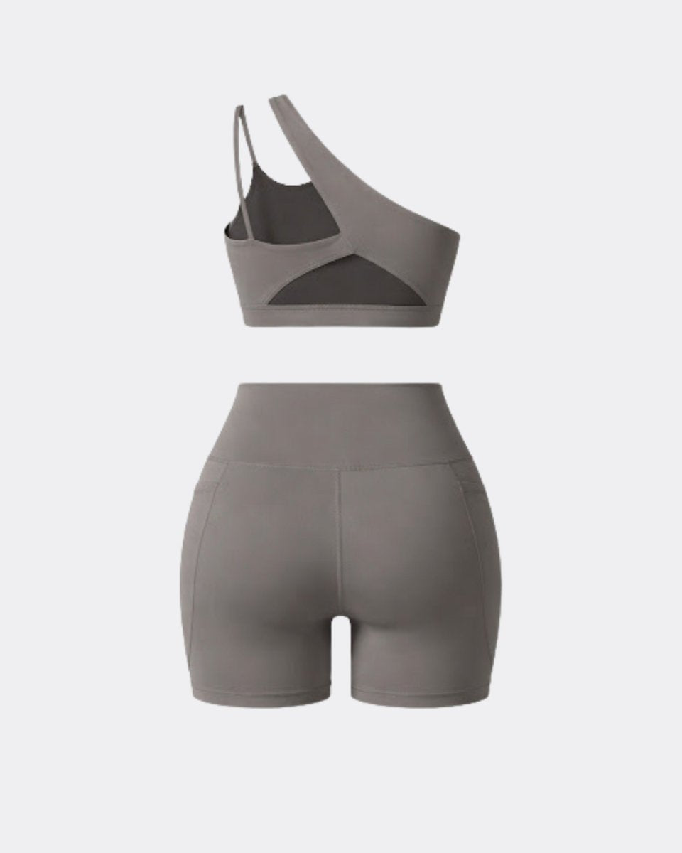 Flat lay back view showing the strappy cutout back of the grey one shoulder activewear matching set.