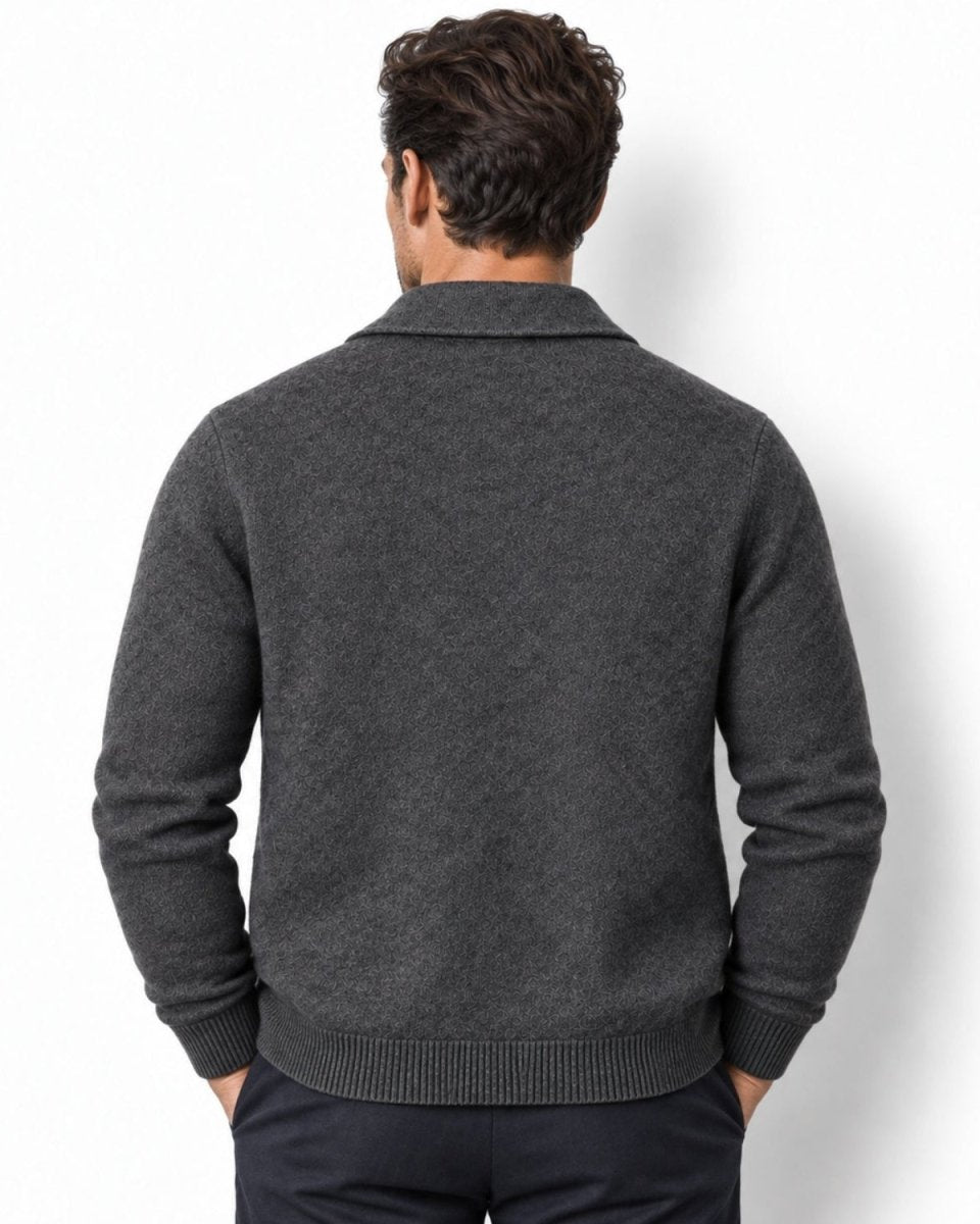A man viewed from behind wearing a dark gray knit sweater with a collar and ribbed cuffs and hem, paired with dark trousers, against a plain white background.