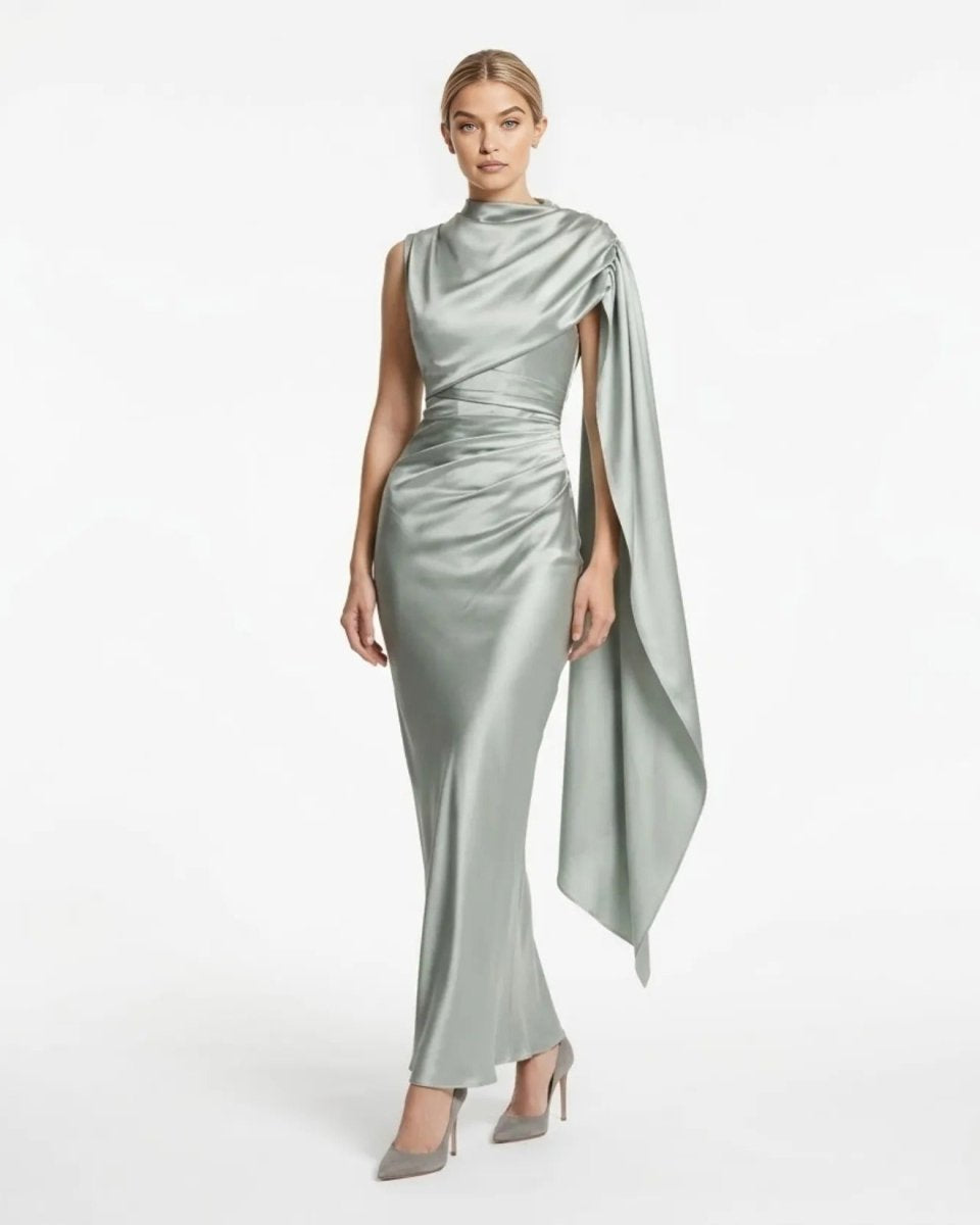 Front view of the sage green satin asymmetrical cape maxi dress showing draped neckline and ruched waistline.