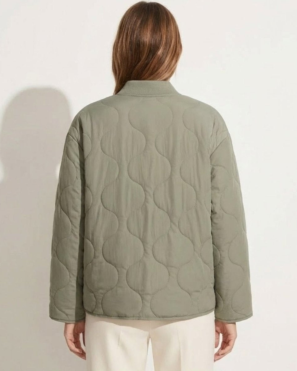 Back view of the Harmony sage green quilted jacket on a model, showcasing the full onion quilting pattern and clean silhouette.
