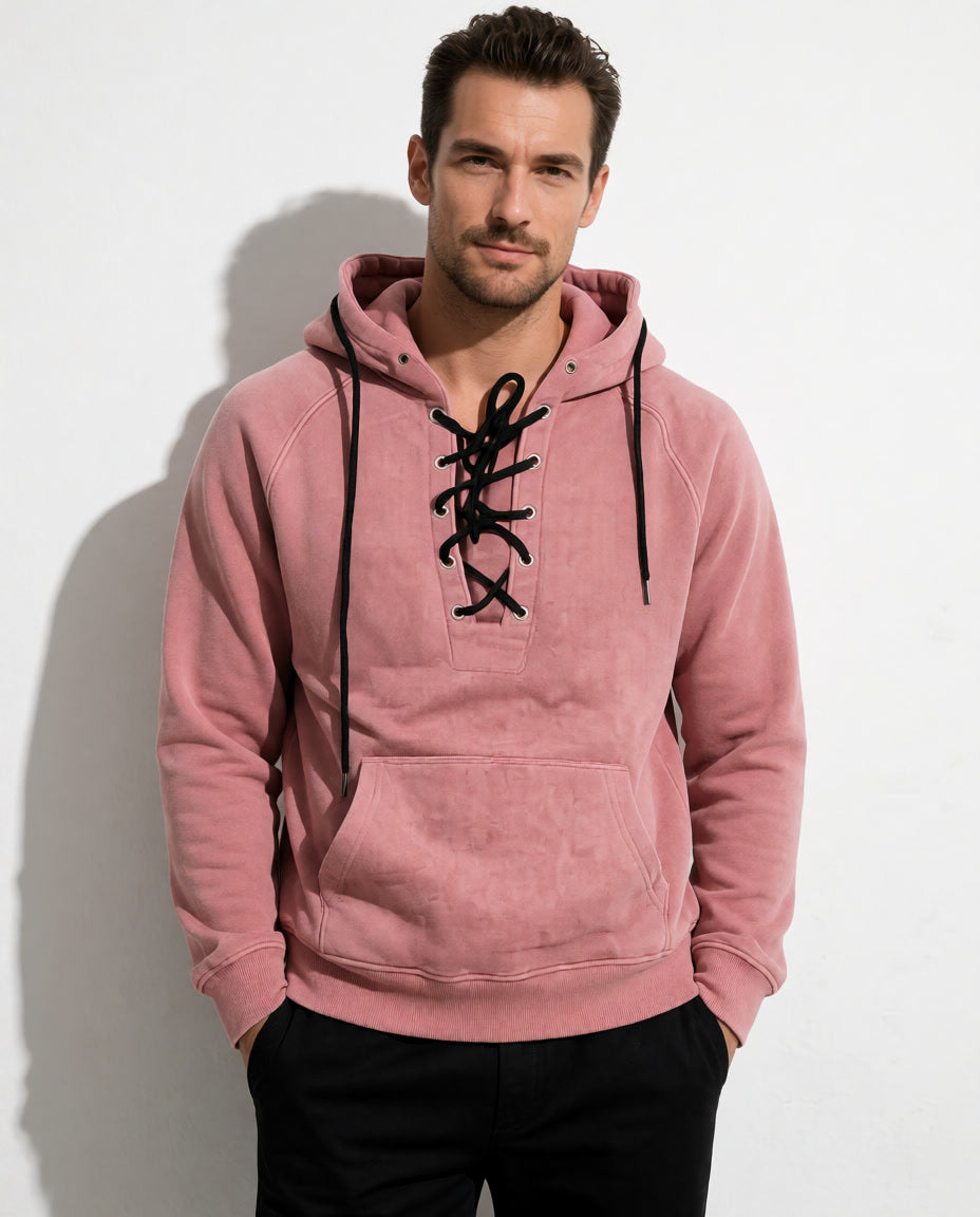 Vorderansicht eines Models im rosafarbenen Cannon Kapuzenpullover mit schwarzer Schnürung und Kängurutasche.