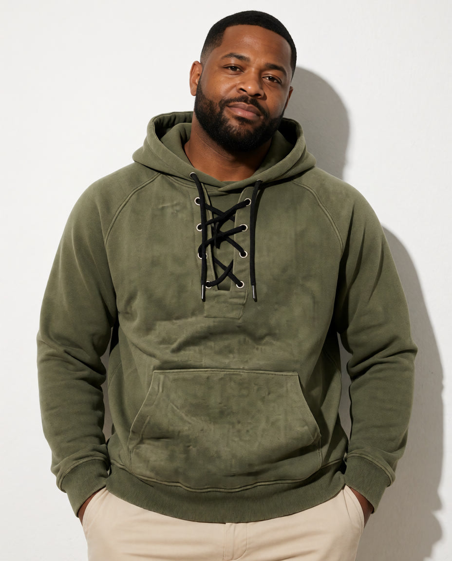 Vorderansicht eines Models im olivgrünen Cannon Kapuzenpullover mit Kängurutasche und heller Hose.