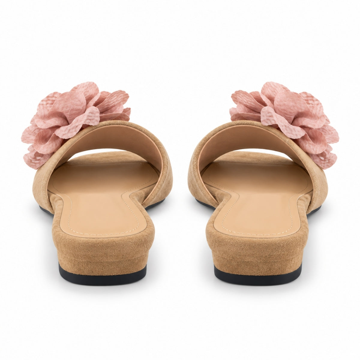 A pair of women's slide sandals shown from the back, featuring a tan suede-like upper with a large textured pink fabric flower on each strap, set against a plain white background.