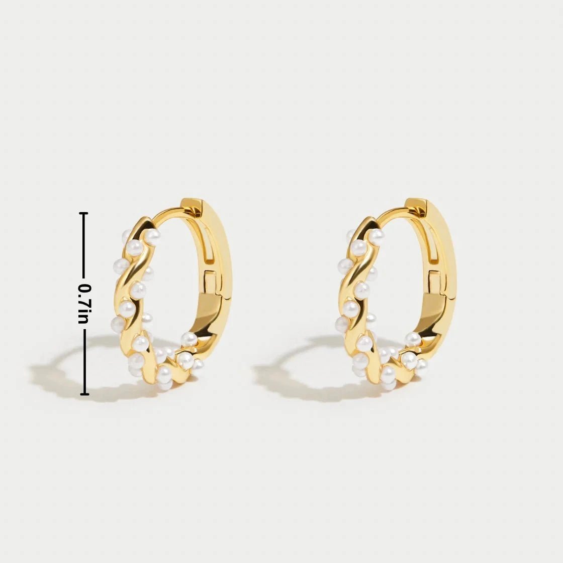 Model wearing Kouvr Kim small 18k gold pearl huggie hoop earrings
