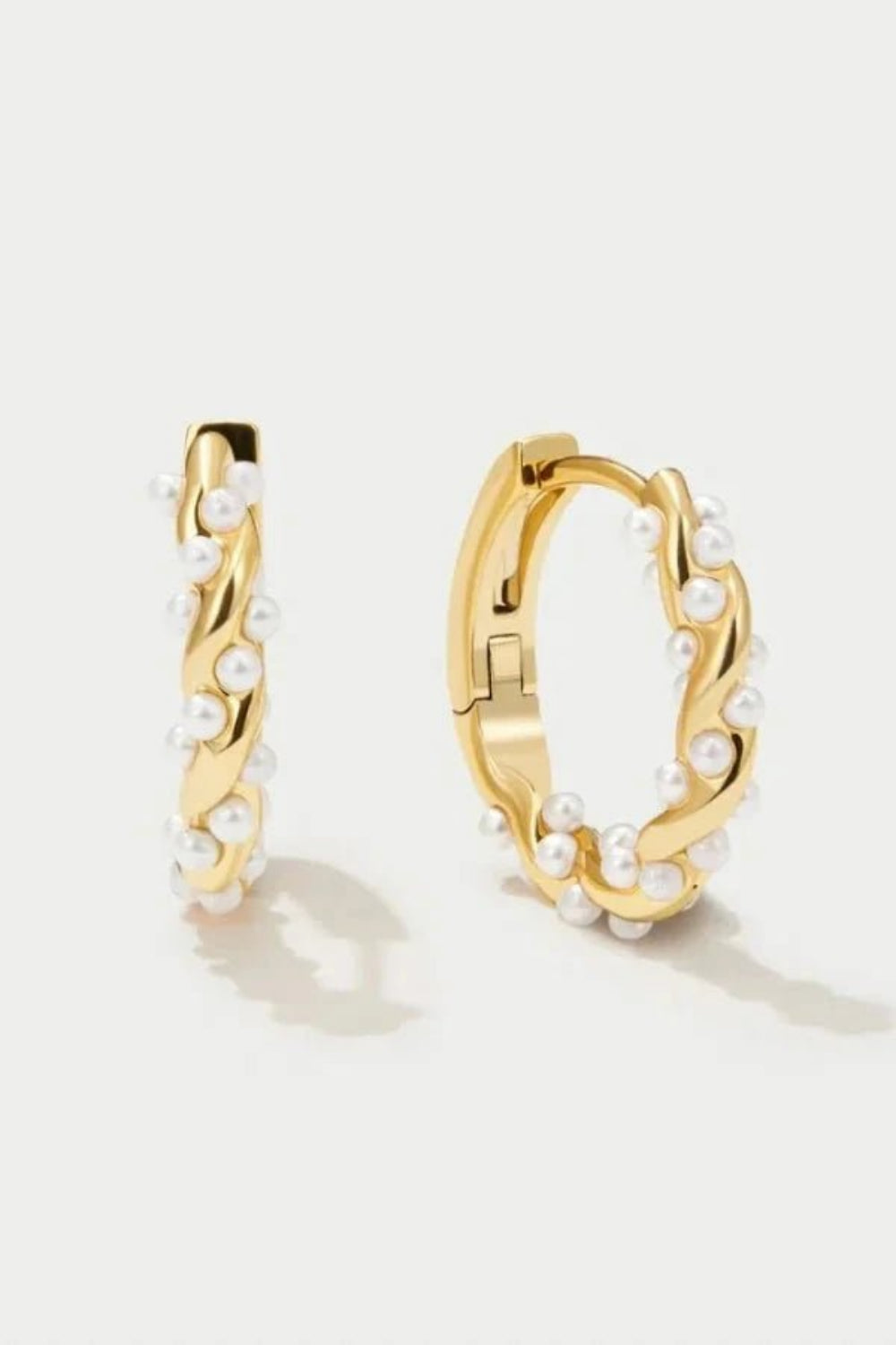 Model wearing Kouvr Kim small 18k gold pearl huggie hoop earrings