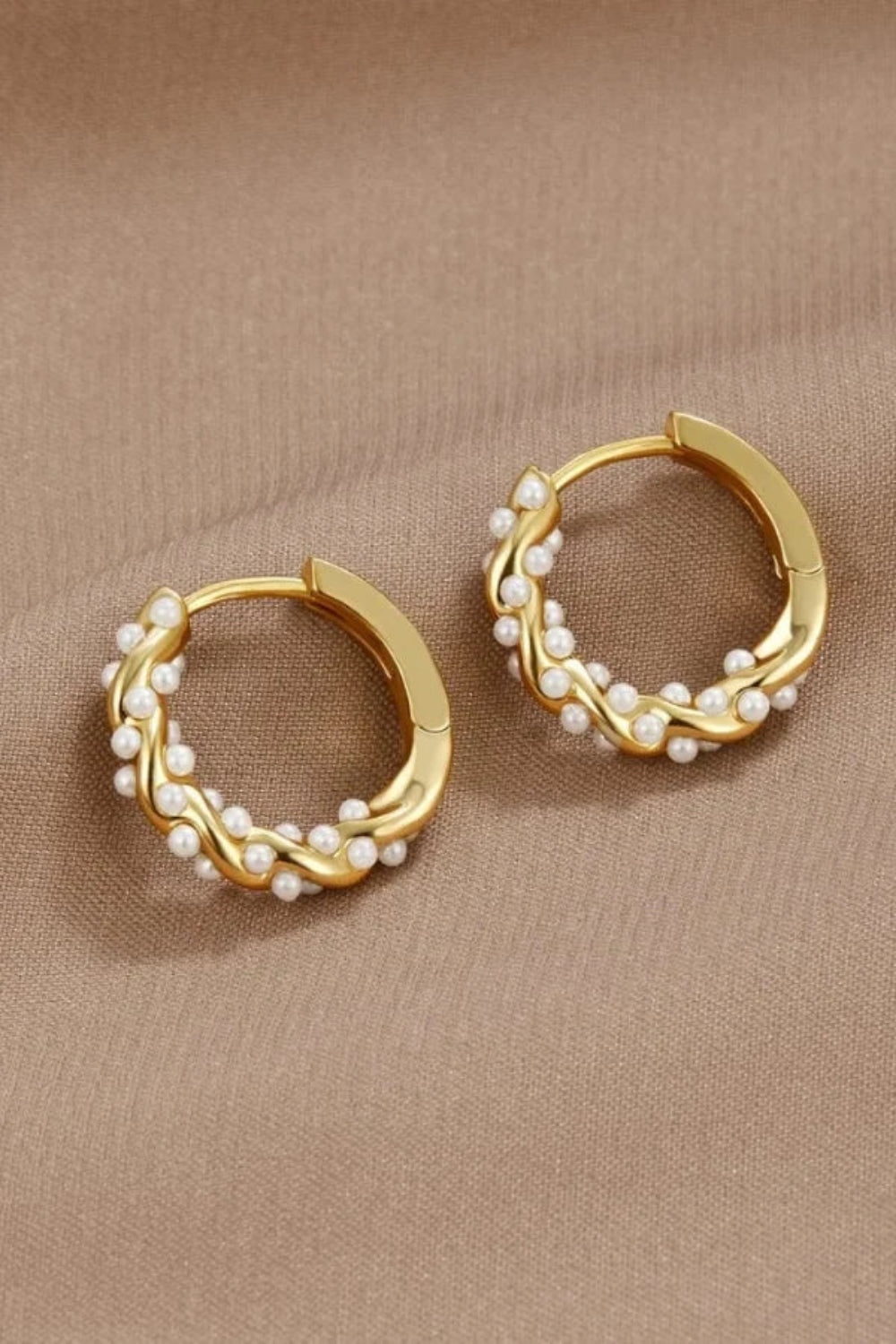 Model wearing Kouvr Kim small 18k gold pearl huggie hoop earrings