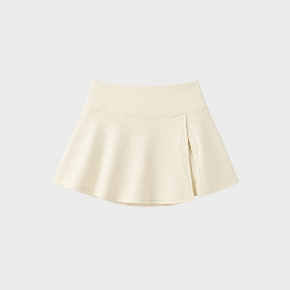 Close up flat lay of Kouvr premium apricot  high-waisted athletic mini skort highlighting subtle front side slit